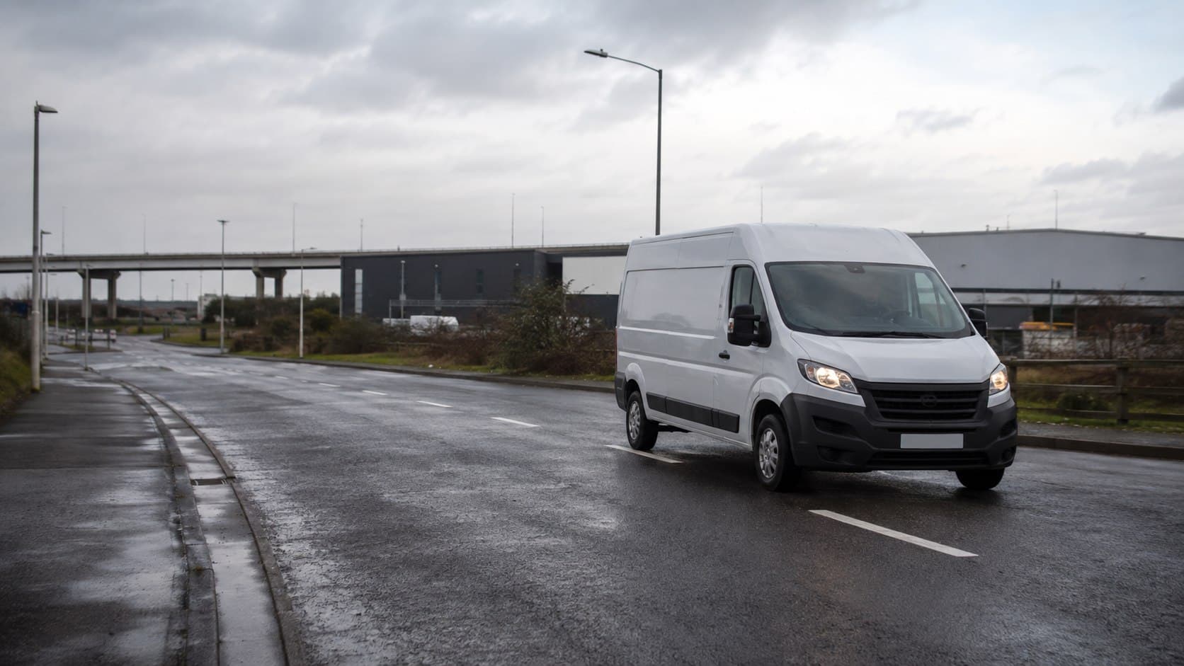 Unbranded courier van travelling through a commercial area in Grays